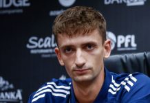 Проблем за Левски преди Арда! Гашпер Търдин остава под въпрос Man in a blue sports jacket sits at a press conference, looking at the camera with a neutral expression, backdrop covered in logos.