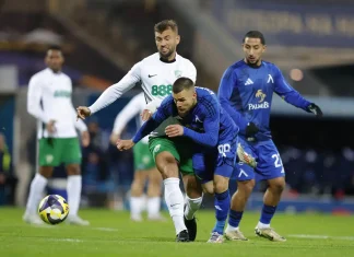 Радослав Кирилов ще бъде опериран отново, този път в Германия Soccer players in white and blue jerseys chasing a ball on a green field during a match, with one player in white ahead of a blue-clad opponent.