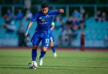 Рилдо Фильо – профил, статистика и кариера Soccer player in blue uniform dribbling a ball on a green field during a match, with spectators in the bleachers in the background