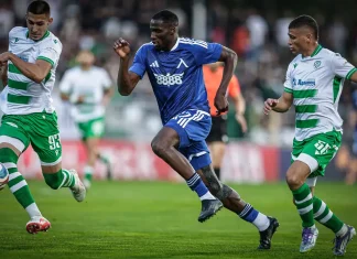 Сангаре пак се контузи, „сините“ мислят за нов нападател Blue-team player in mid-run dribbles the ball while two green-and-white striped players pursue him on a soccer field.