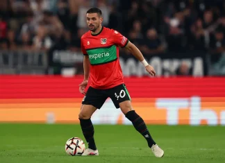 Скандал в НЕК преди Левски: Фенове поискаха главата на Душан Тадич Soccer player in a red and green jersey dribbles the ball on the pitch during a match.