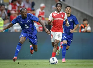 Турски клубове следят звезда на Левски Soccer player in blue kit lunges toward the ball as other players in blue and red kits chase behind on a grassy field.