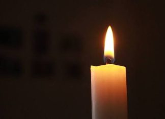 Тъжна новина за Левски: Почина бившият защитник на сините Lit white candle with a bright flame in a dark room, casting a warm glow.