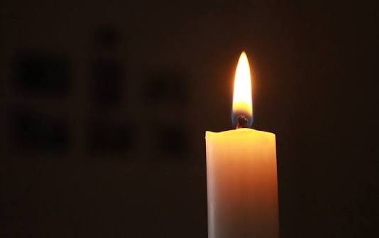 Тъжна новина за Левски: Почина бившият защитник на сините Lit white candle with a bright flame in a dark room, casting a warm glow.