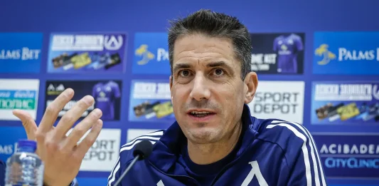 Веласкес готви промени в Левски, но няма да пипа най-силното си оръжие Man in a blue athletic jacket speaks at a press conference with a microphone in front; sponsor boards are blurred in the background.