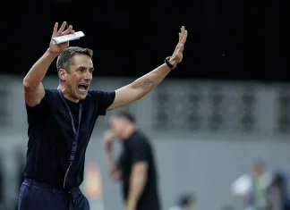 Веласкес готви промени срещу Виктория Пилзен Coach celebrating with arms raised, holding a folded paper in his left hand, wearing a dark shirt and lanyard.
