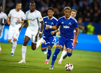 Веласкес готви промяна в атаката на Левски за НЕК Soccer player in a blue kit controls the ball while defenders in white chase him on the field.