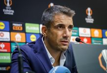 Веласкес готви сериозни промени в Левски за НЕК Man in a blue suit speaks into a microphone at a press conference with sponsor banners in the background