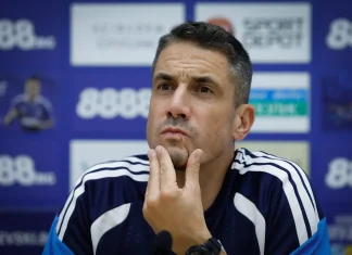 Веласкес има своя човек за „Тича“ Man in a navy sports jersey at a press conference, touching his chin with a thoughtful expression.